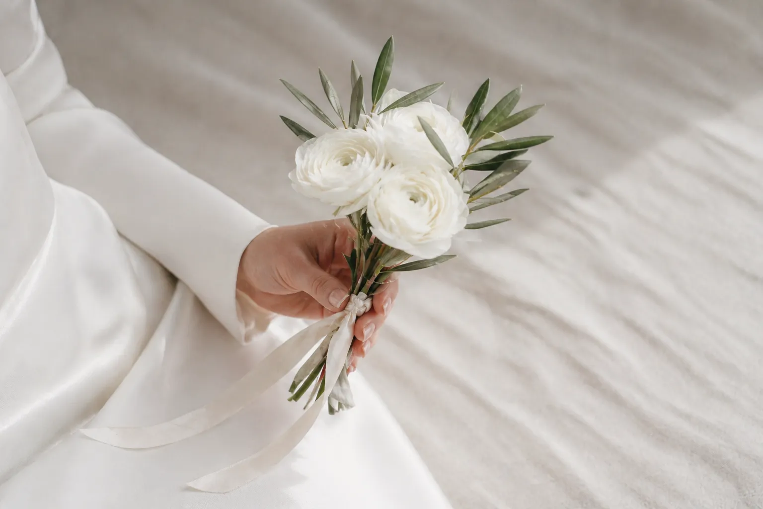 Маленький букет невесты из трёх белых ранункулюсов и ветки оливы